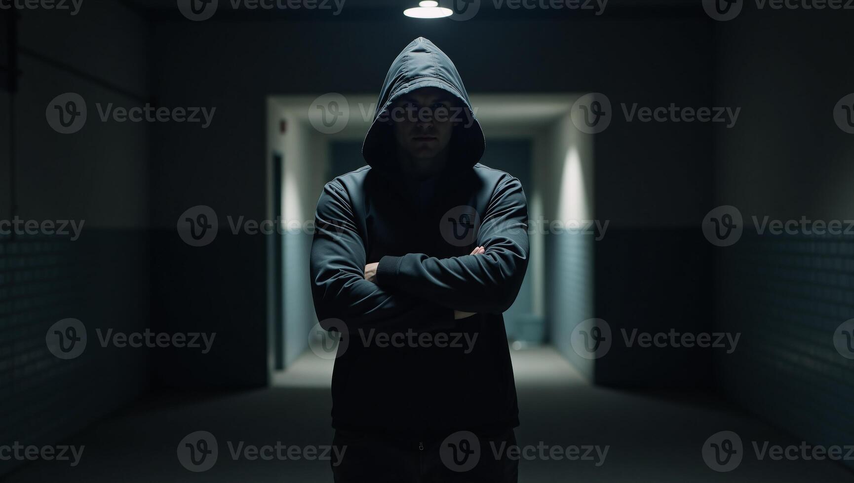 Man in hooded jacket appears in dimly lit corridor photo