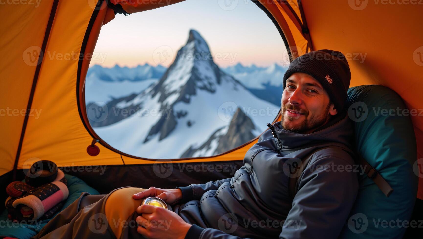 Hiker camping in a tent on a mountain peak photo
