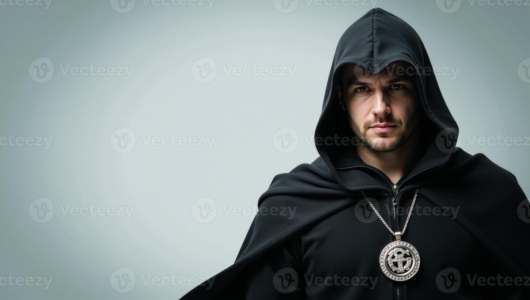 Hooded man with determined look displaying emblem of protection before a digital backdrop photo
