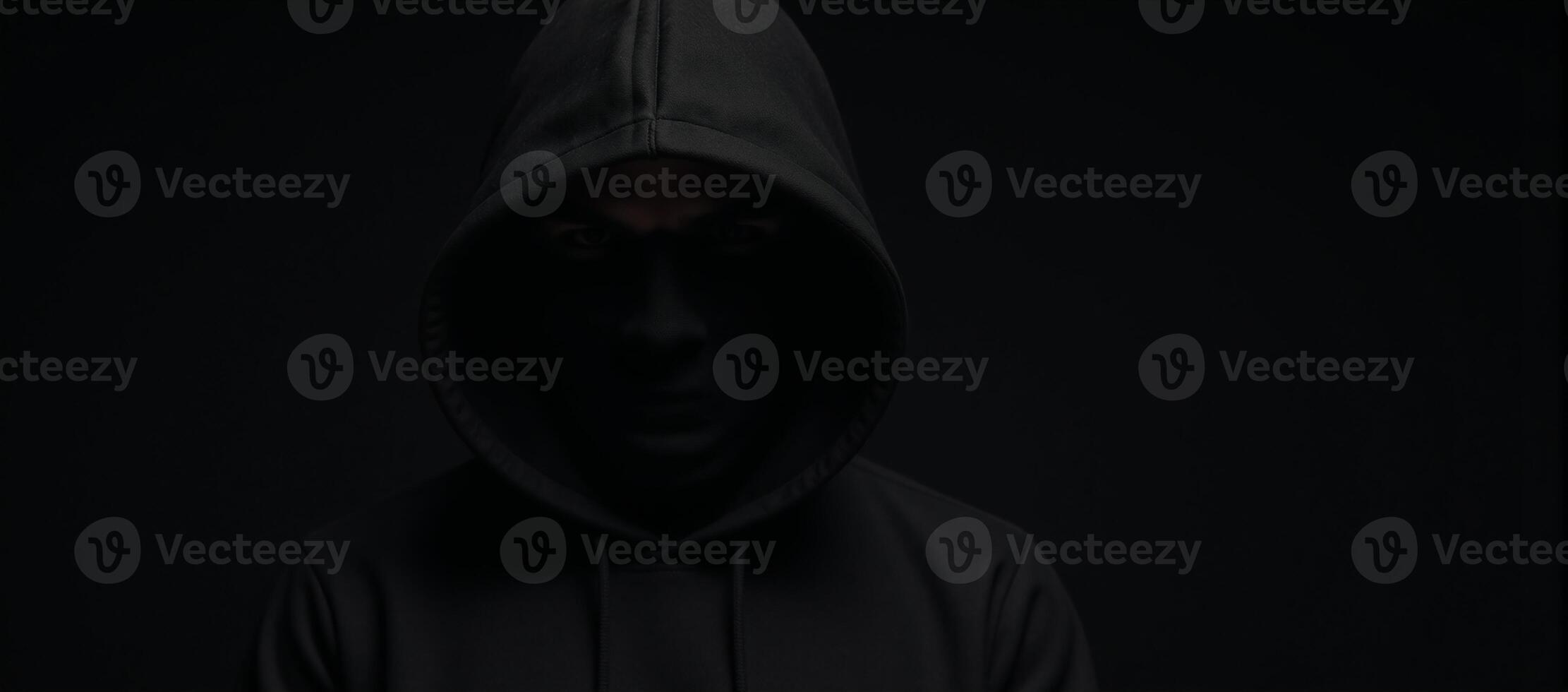 Computer Hacker Blackhooded figure in Dark Moody Background photo