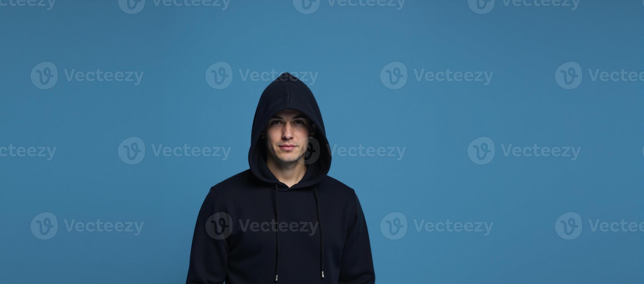 Hooded figure against blue backdrop photo