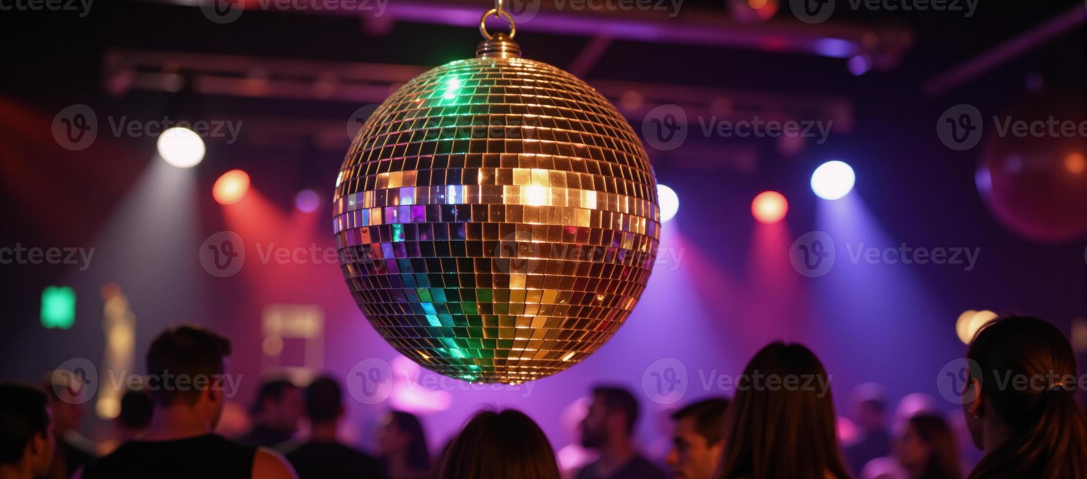 Glowing disco ball illuminates club dance floor with vibrant rainbows photo