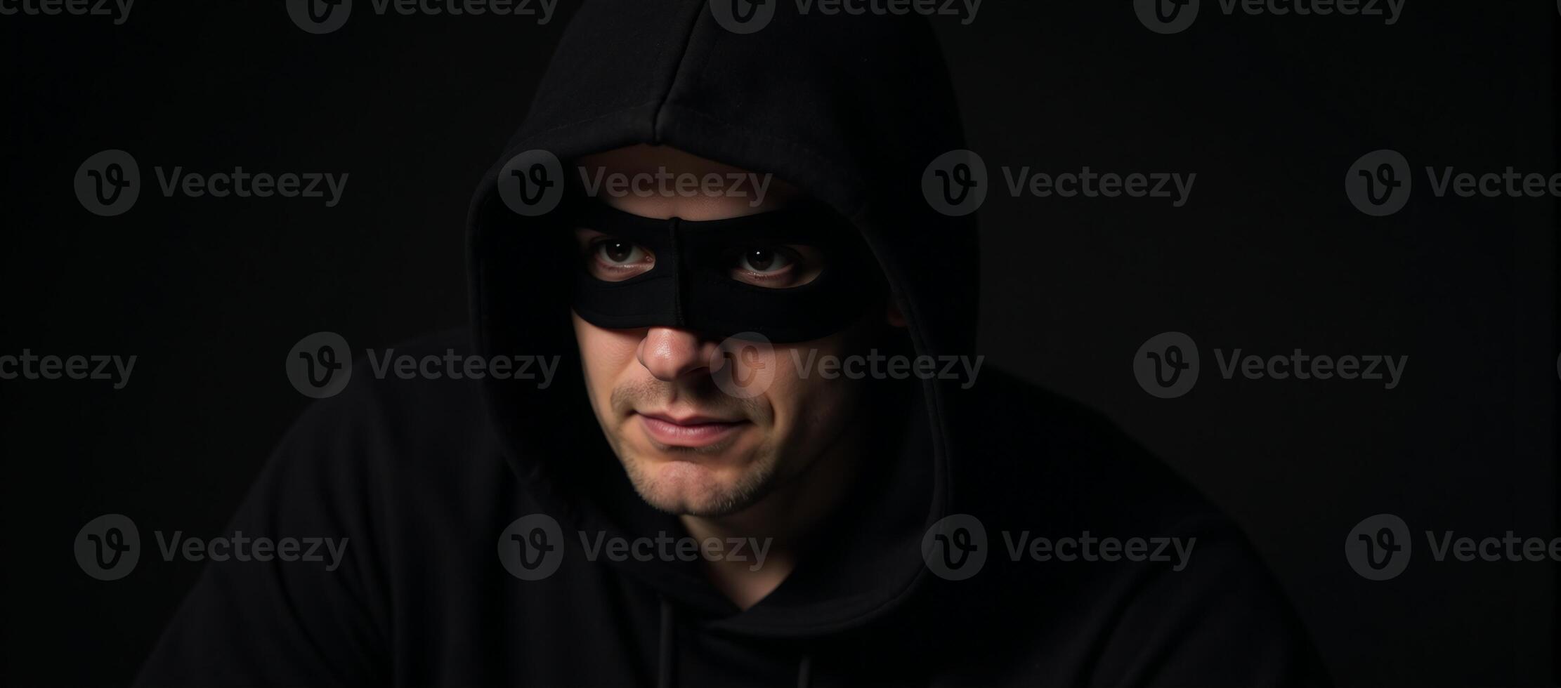 Criminal man with hooded appearance gazes at dangerous backdrop photo