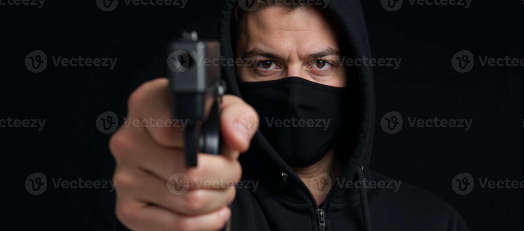 Attacker brandishing weapon gun targets individual donning black mask and hoodie in threatening scenario photo