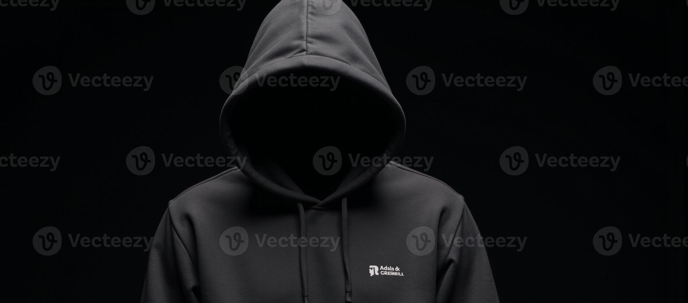 A lone figure dressed in a hooded sweatshirt stands amidst darkness and blurred shadows photo
