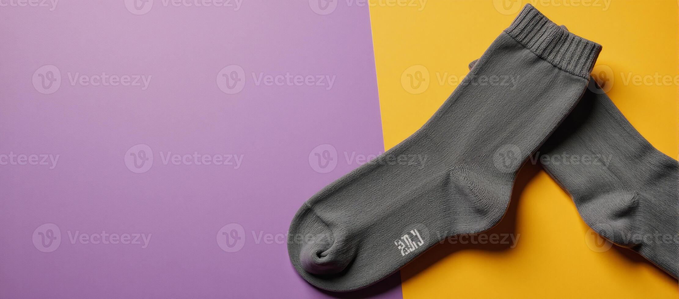 Highangle shot of two pairs of gray socks against a vibrant backdrop photo
