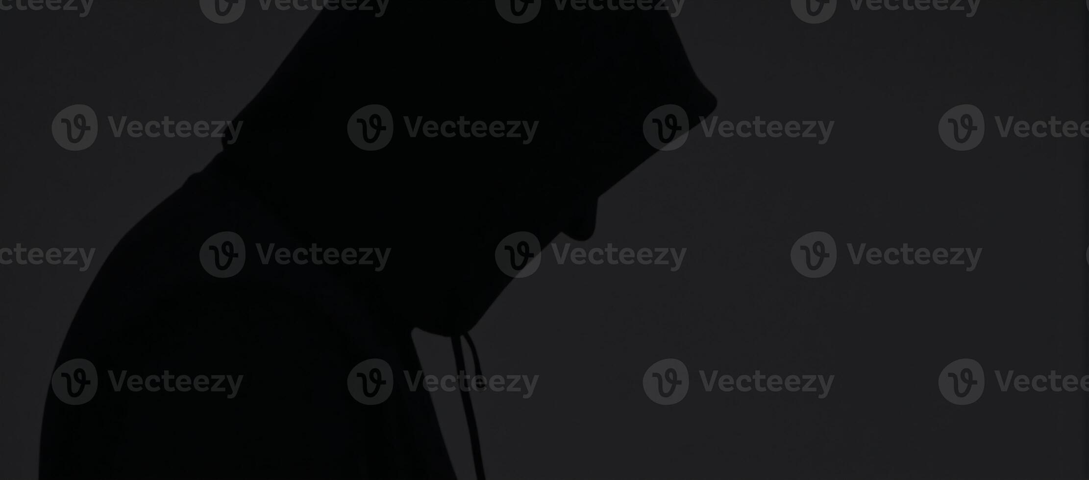 Man silhouetted with hood on dark backdrop anonymous figure in hoodie photo