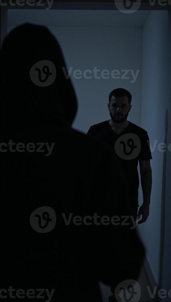 A man wearing a hood stalks someone on a dark night with criminal intent robbery or assault photo