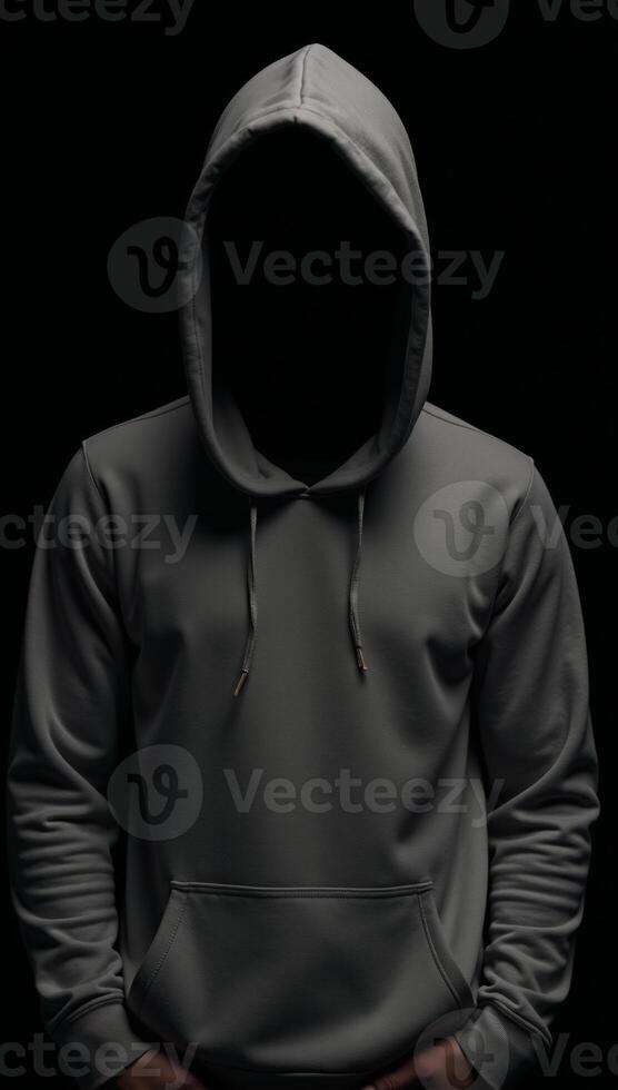 A lone figure dressed in a hooded sweatshirt stands amidst darkness and blurred shadows photo