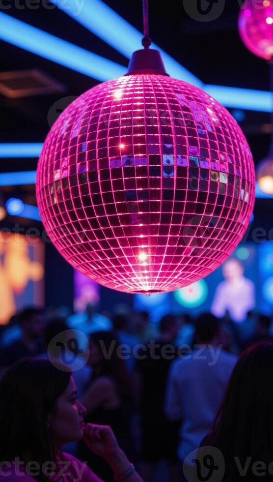 A closeup image featuring a lively disco scene against a backdrop of vibrant neon lights and a sparkling pink disco ball photo