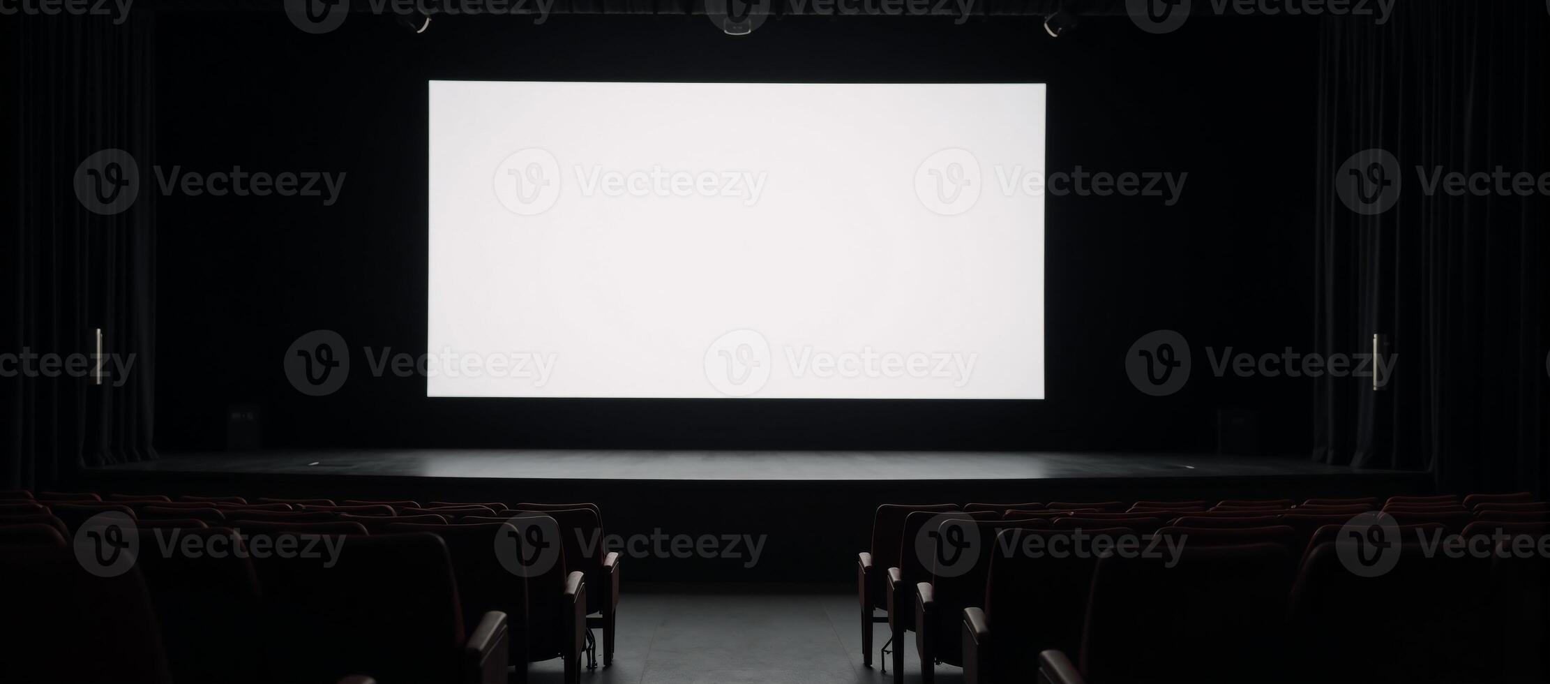 A staged venue featuring rows of empty seats and a large blank screen photo