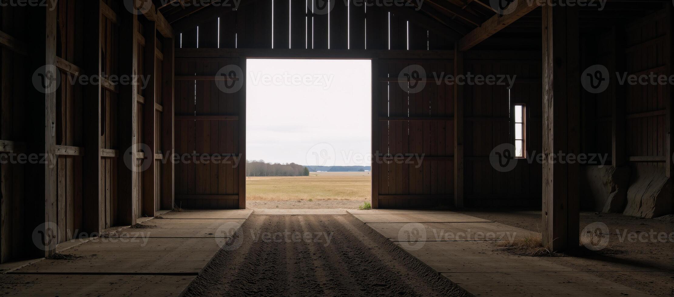 Large empty barn featuring an illuminated entranceway photo