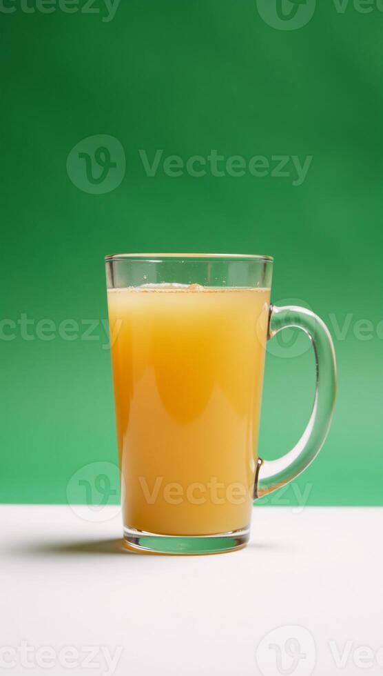 Apple juice in a handled glass set against a pristine white backdrop photo