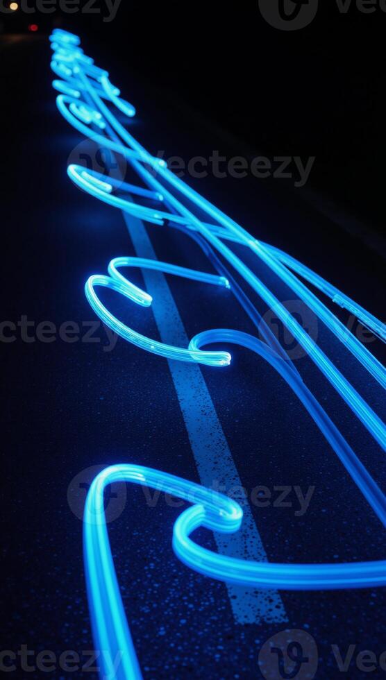 Blue trail lights paint dynamic curved patterns along the winding road photo