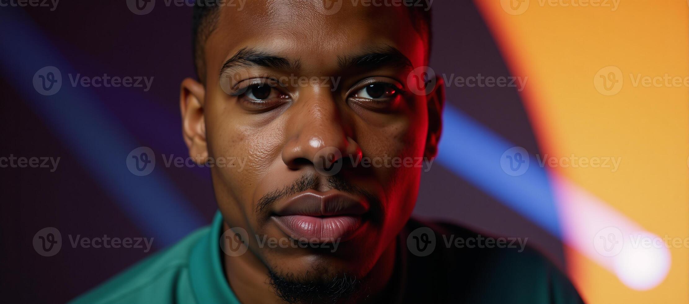 Portrait features a young African American man with geometric facial structure against a backdrop of vibrant neon colors photo