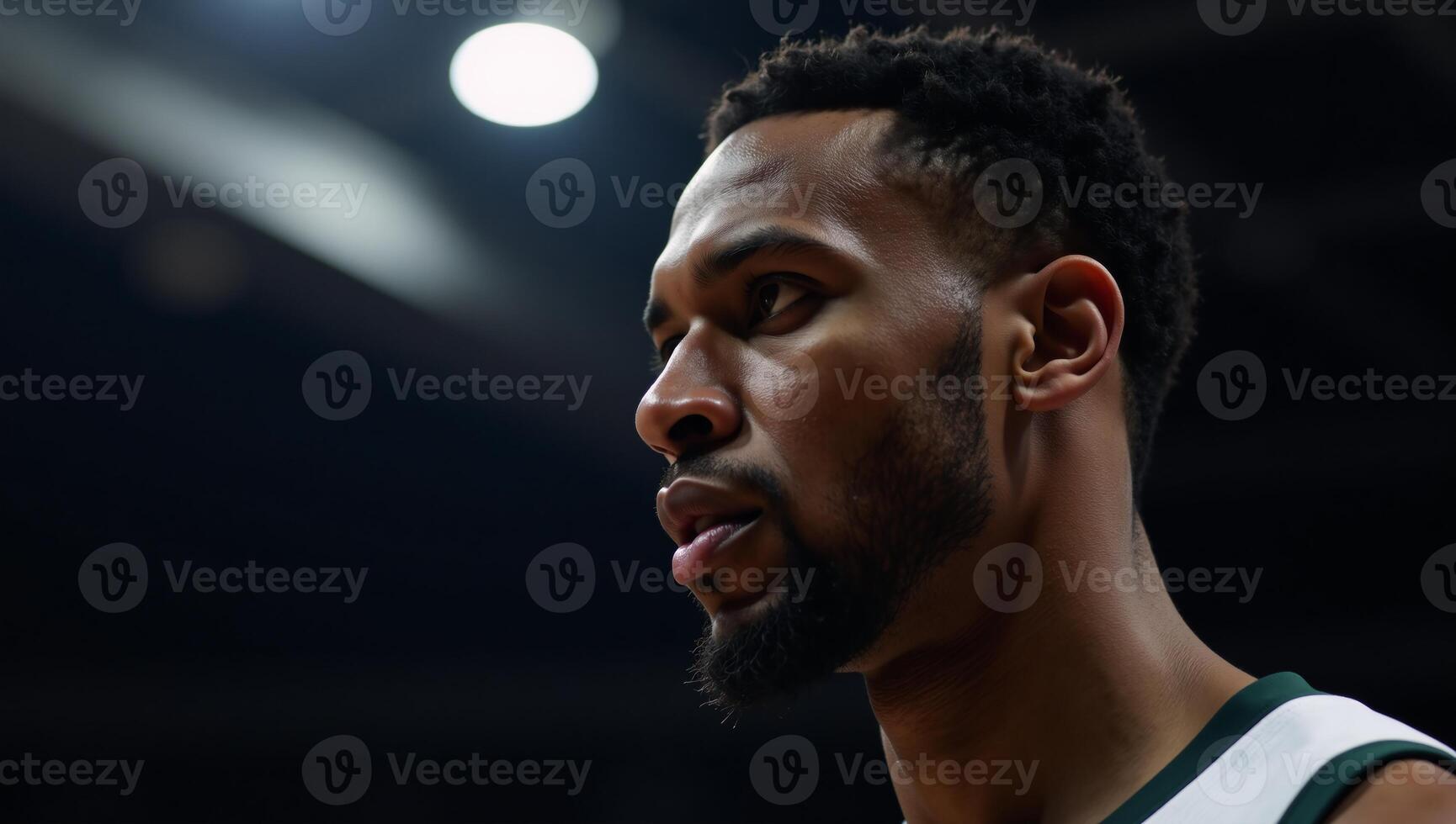 Closeup portrait of an African American basketball player defiant expression lit by a single courtlight photo