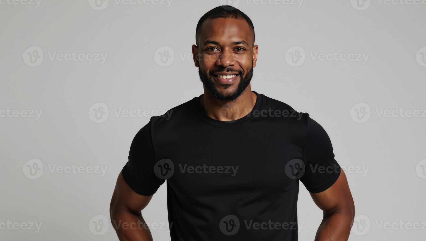 A confident AfricanAmerican model showcases the flexibility of a fitted black tee on a neutral backdrop photo