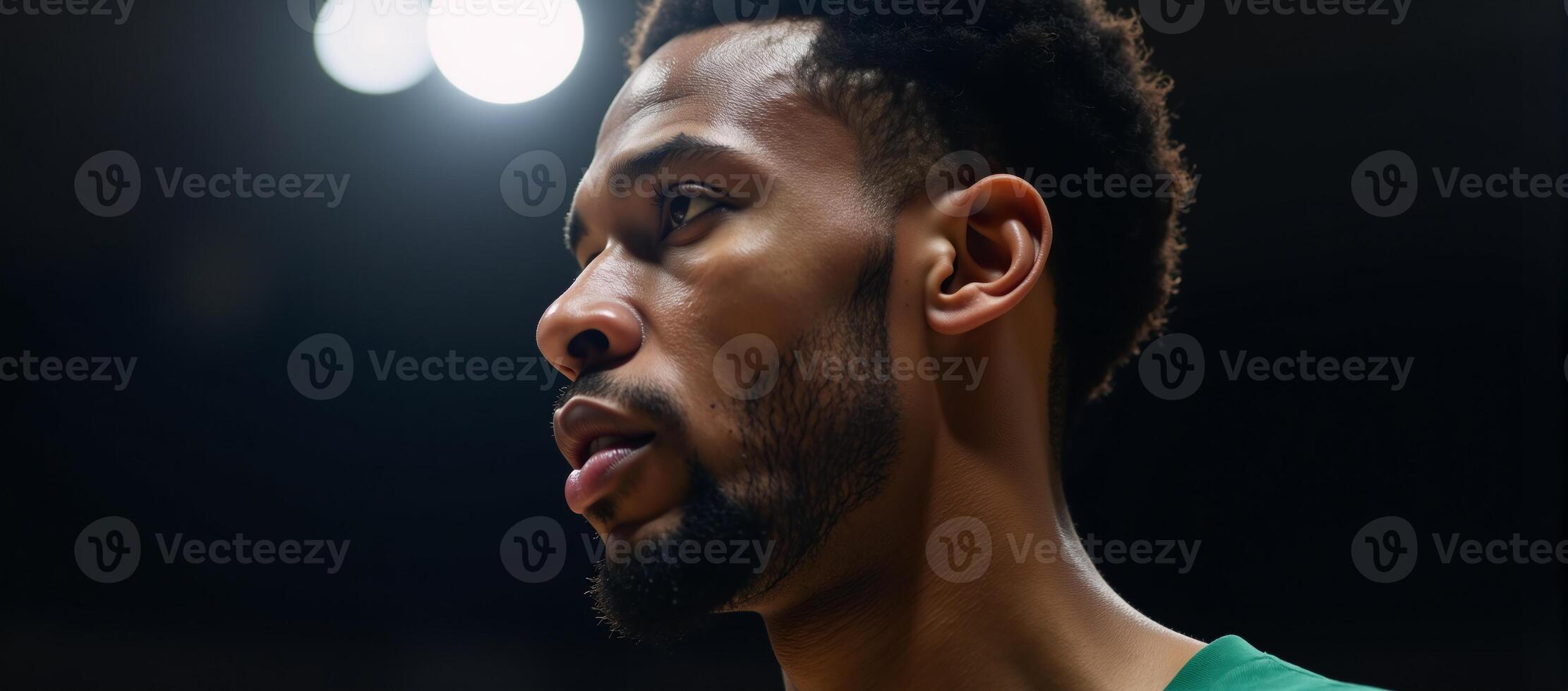 Closeup portrait of an African American basketball player defiant expression lit by a single courtlight photo