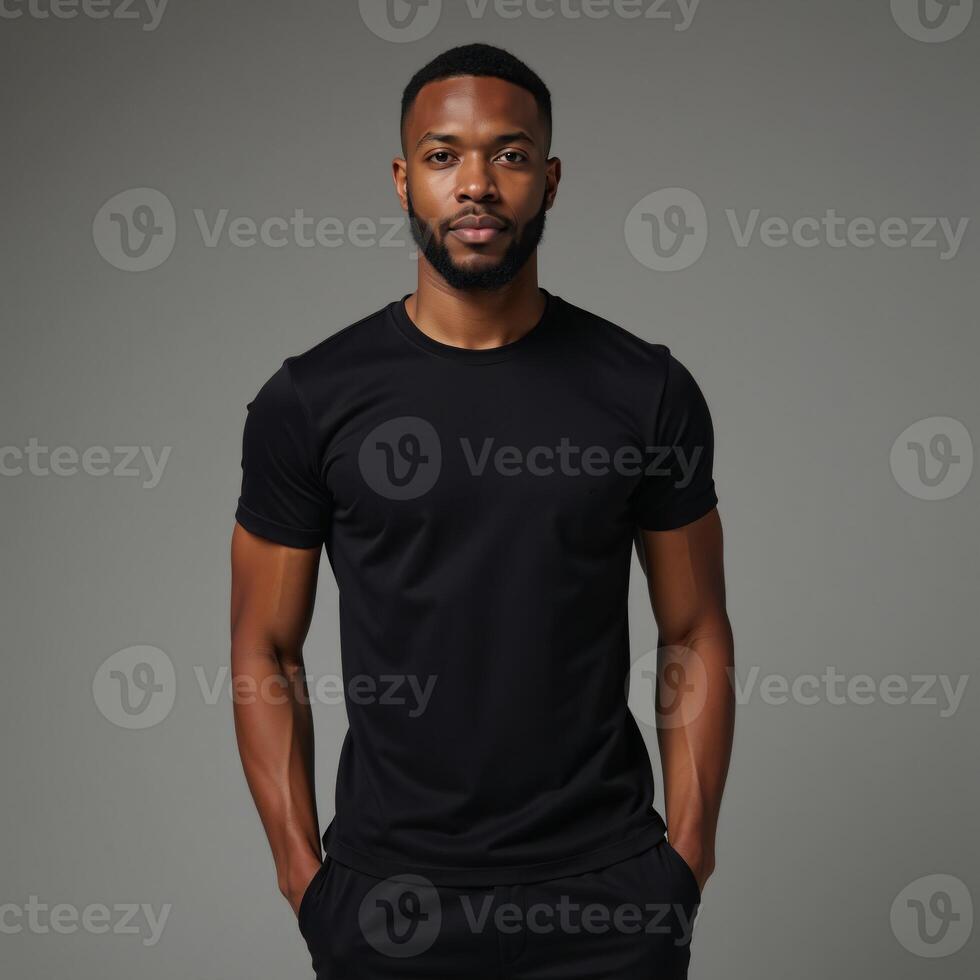 A confident AfricanAmerican model showcases the flexibility of a fitted black tee on a neutral backdrop photo