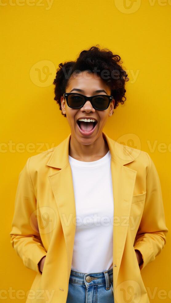 Excited black Gen Z woman with sunnies and shocked expression in front of a brightyellow background promoting summer sales and travels photo