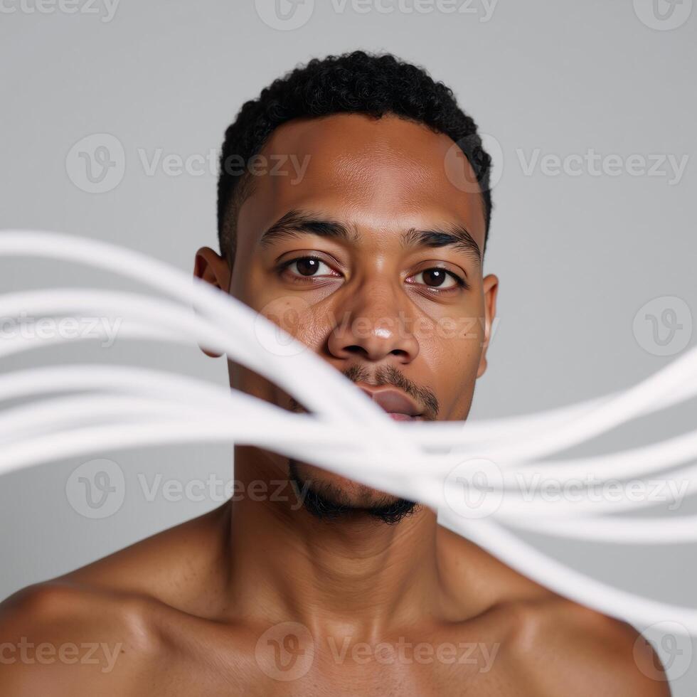 A vibrant portrait showcases an abstracted image of a young African American man set against a light backdrop with lively decorative wave patterns photo