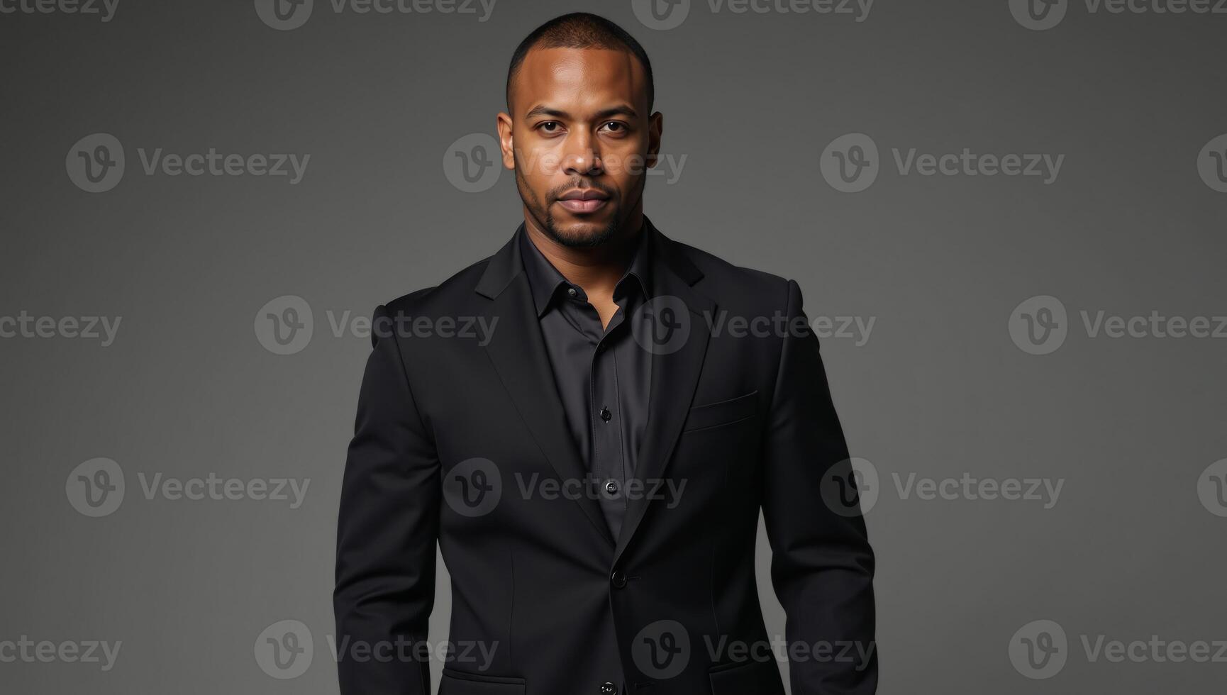 Black studio portrait Tattooed man in black suit gazes seriously into the camera his body art on display against a monochrome backdrop photo