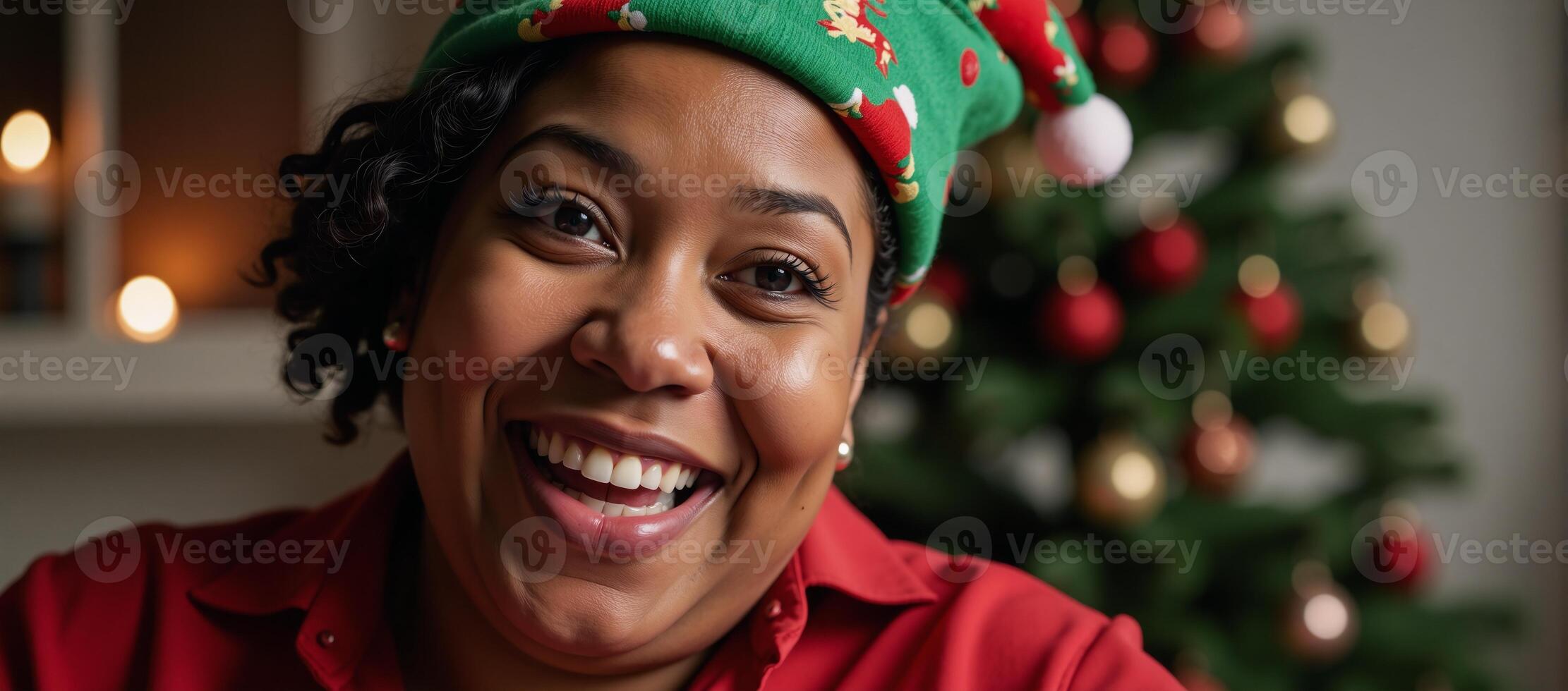 Plussize African American woman engages joyfully over a holiday call while donning a festive Santa hat photo