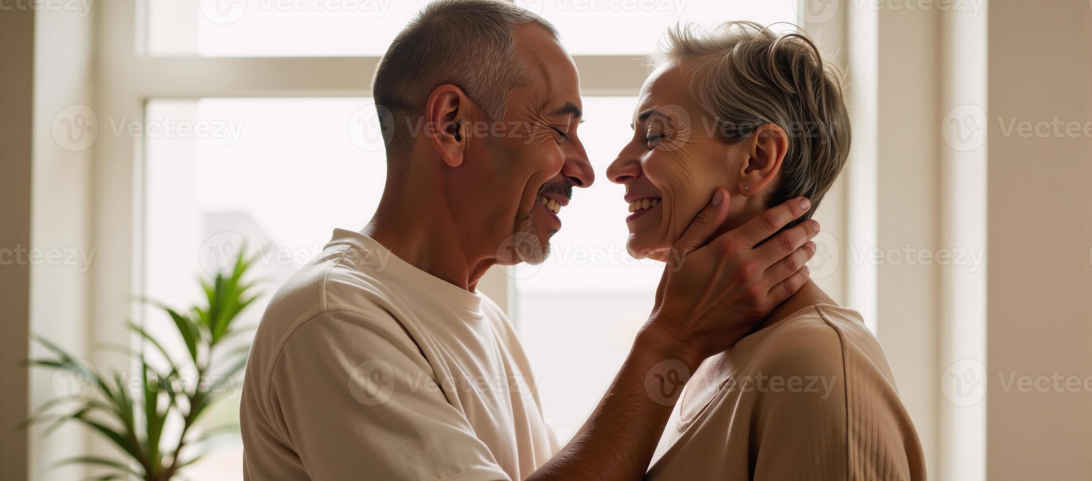 A sunlit window frames an embrace between two middleaged African American individuals photo