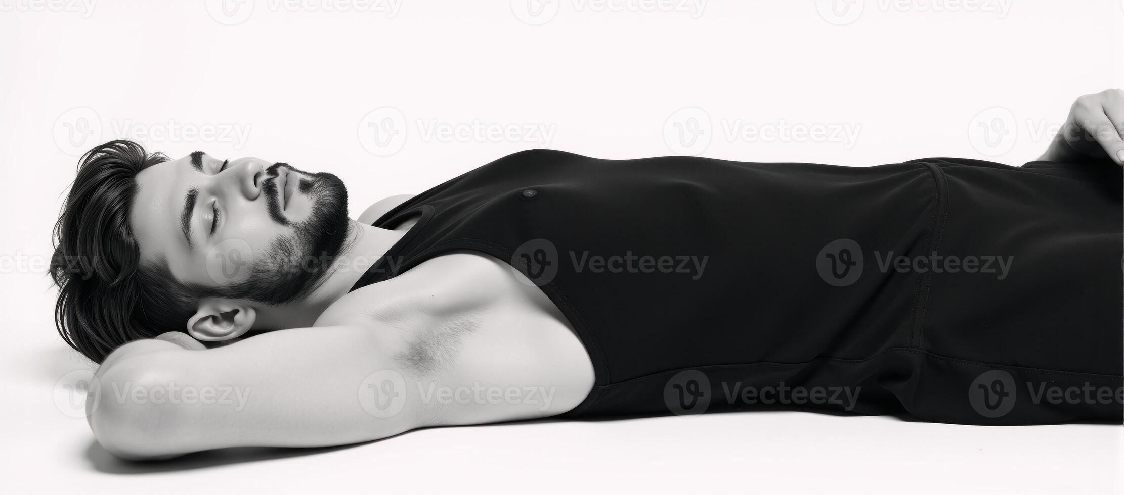 A black bearded teen sleeps or relaxes in a black tank top against an isolated white background photo
