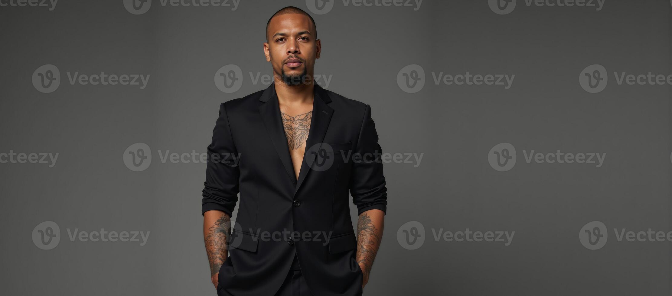 Black studio portrait Tattooed man in black suit gazes seriously into the camera his body art on display against a monochrome backdrop photo
