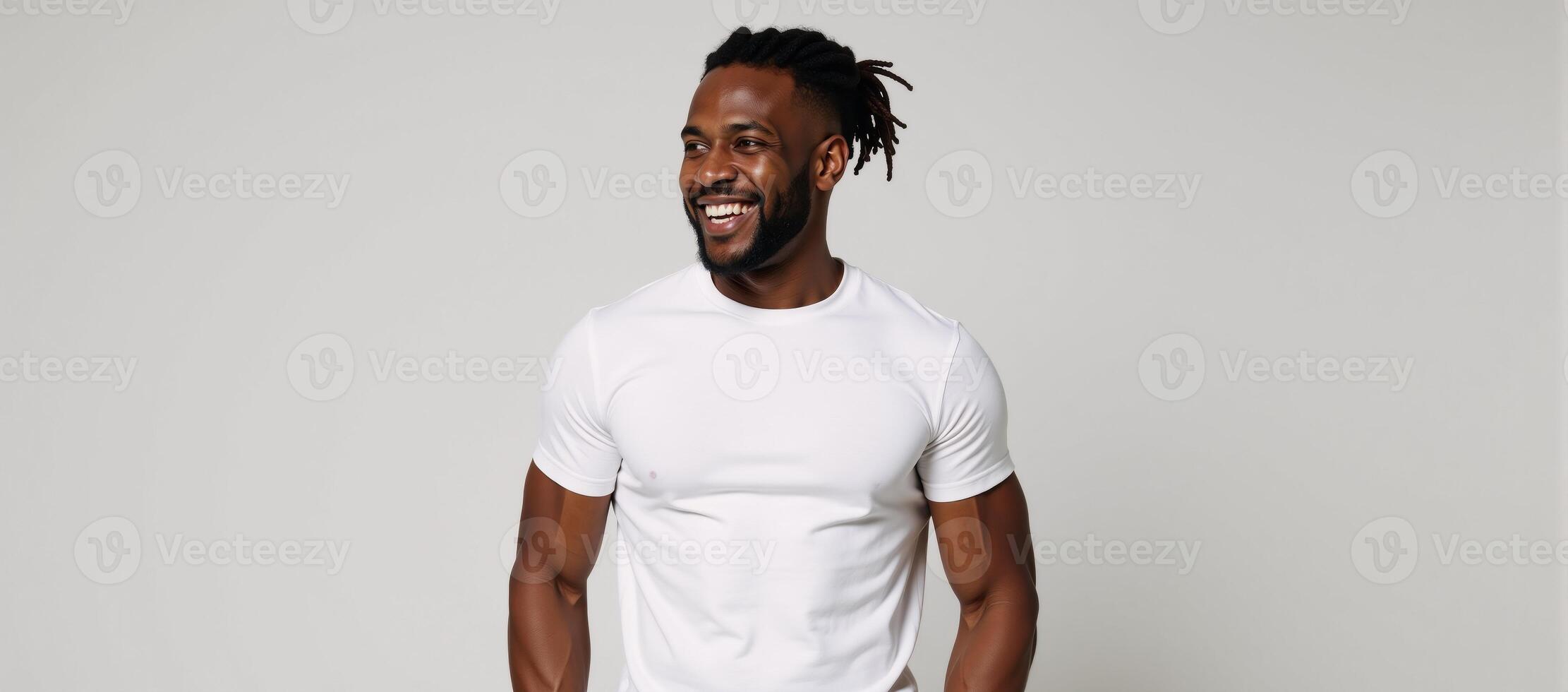 A muscular African American man sporting dreadlocks offers a warm smile photo