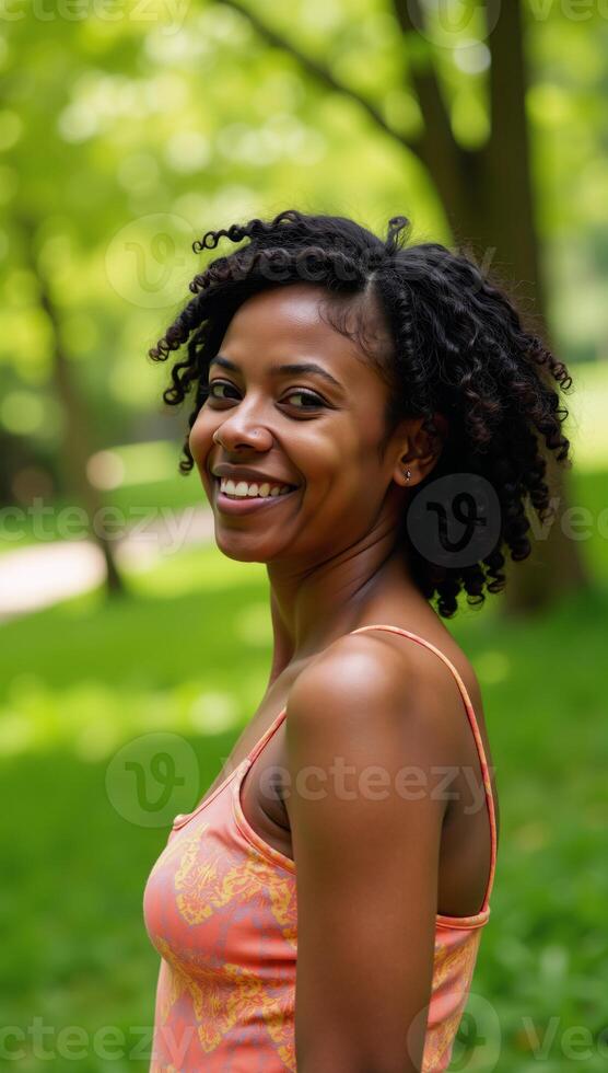 A joyful AfricanAmerican woman with natural hair smiles in a serene nature setting photo