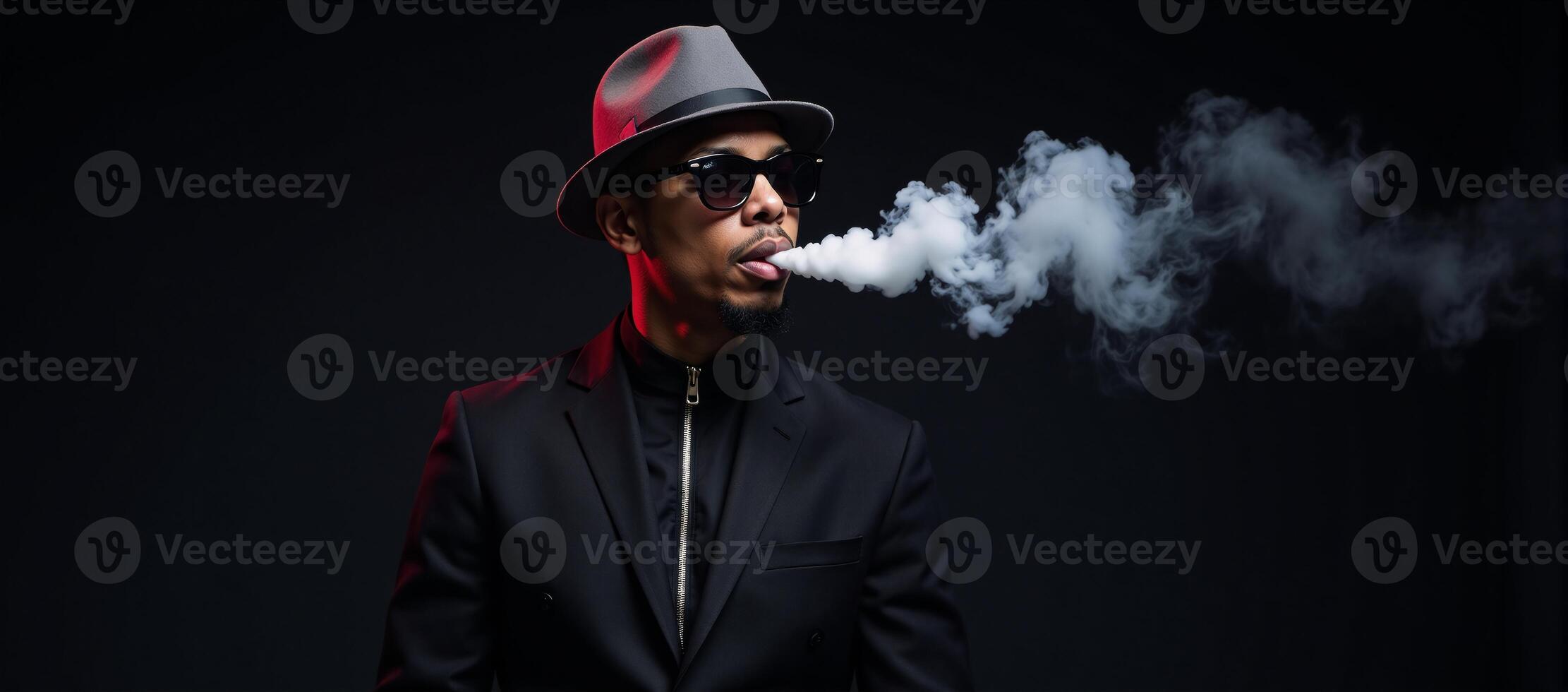 Stylized male figure dons hat sunglasses against a black backdrop illuminated by neon lighting as he vapes in a studio setting the image is highlighted by white accents photo