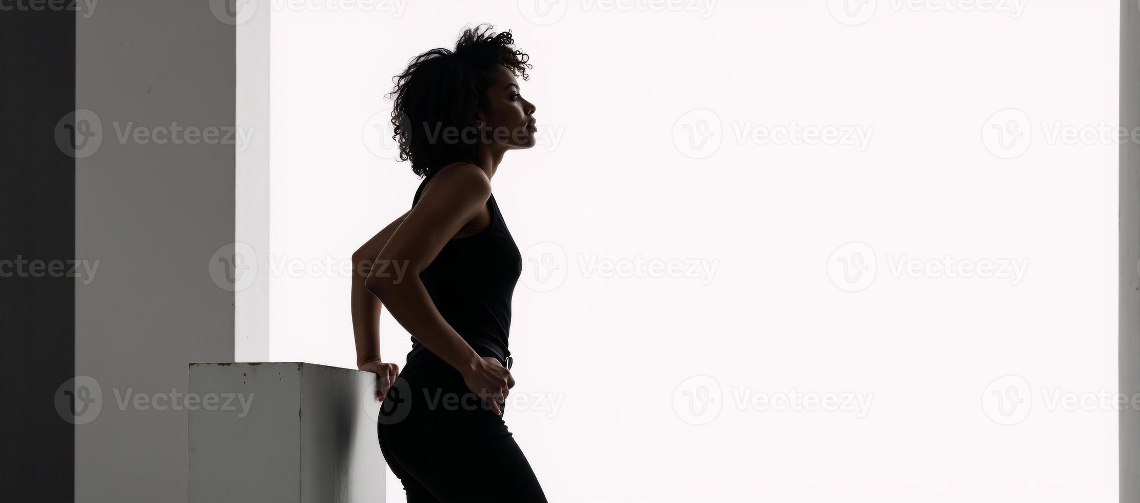 Black silhouette of an AfricanAmerican woman with curls on a white background casual attire profile view photo