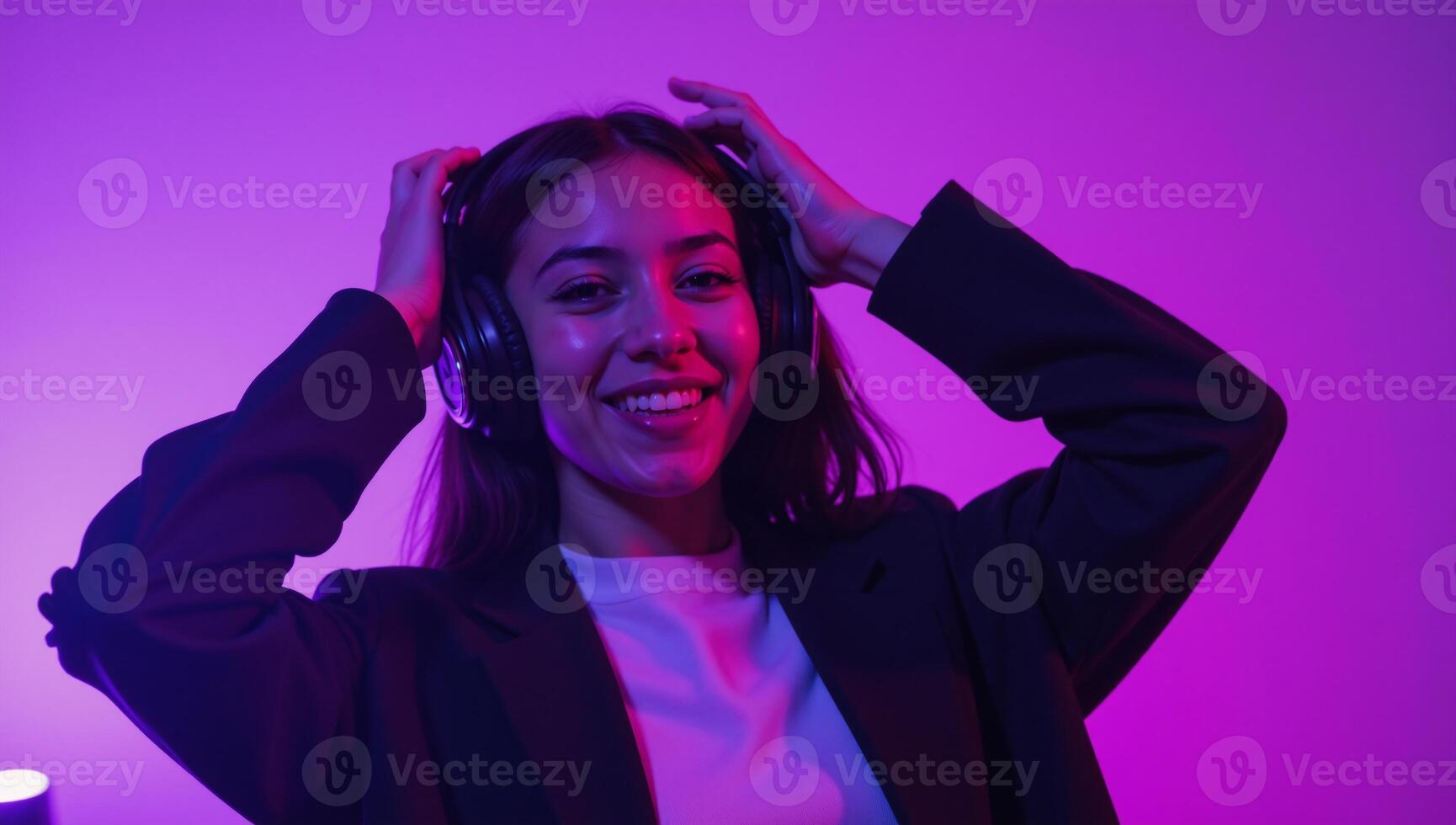 Trendy AfricanAmerican teenager dancing and listening to music under violet lights photo