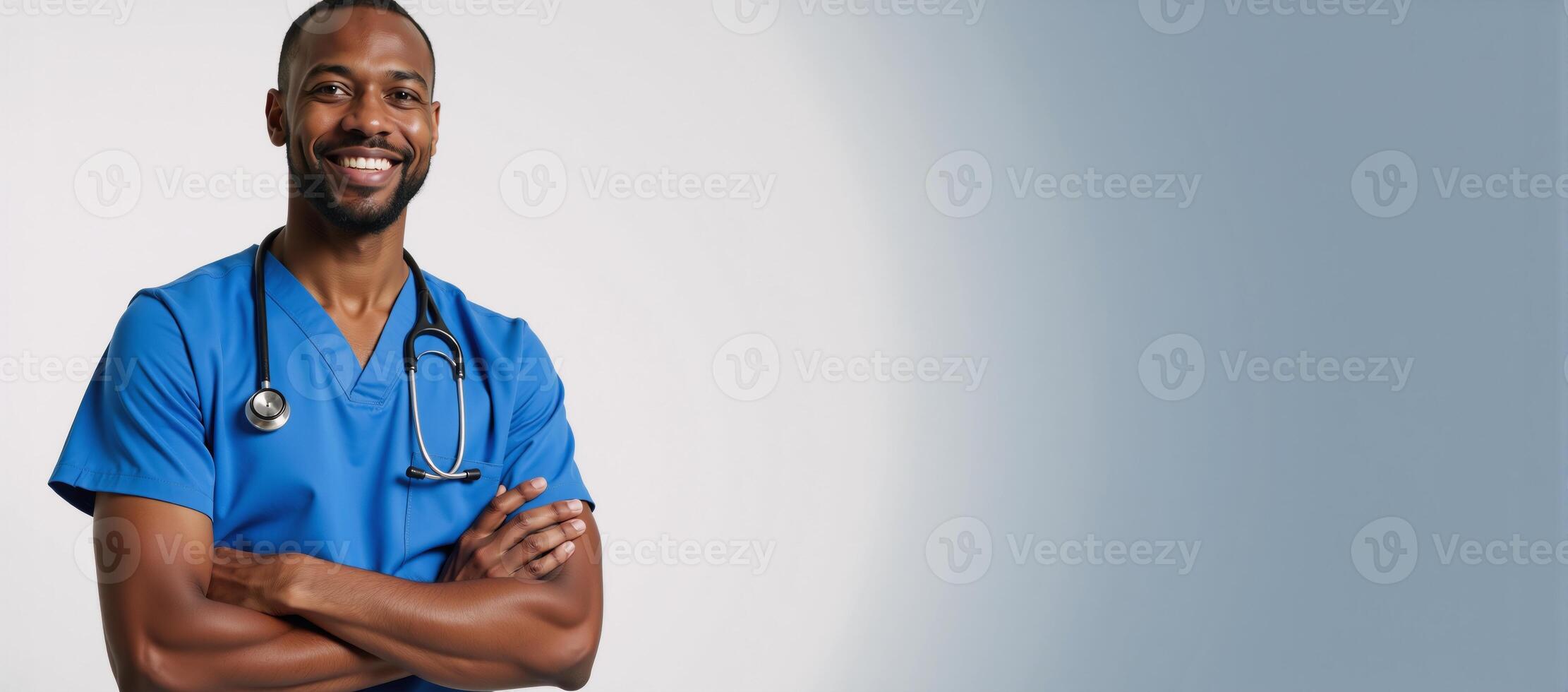 A friendly AfricanAmerican male nurse stands confidently in his blue scrubs smiling warmly while holding a stethoscope embodying caring and compassion photo