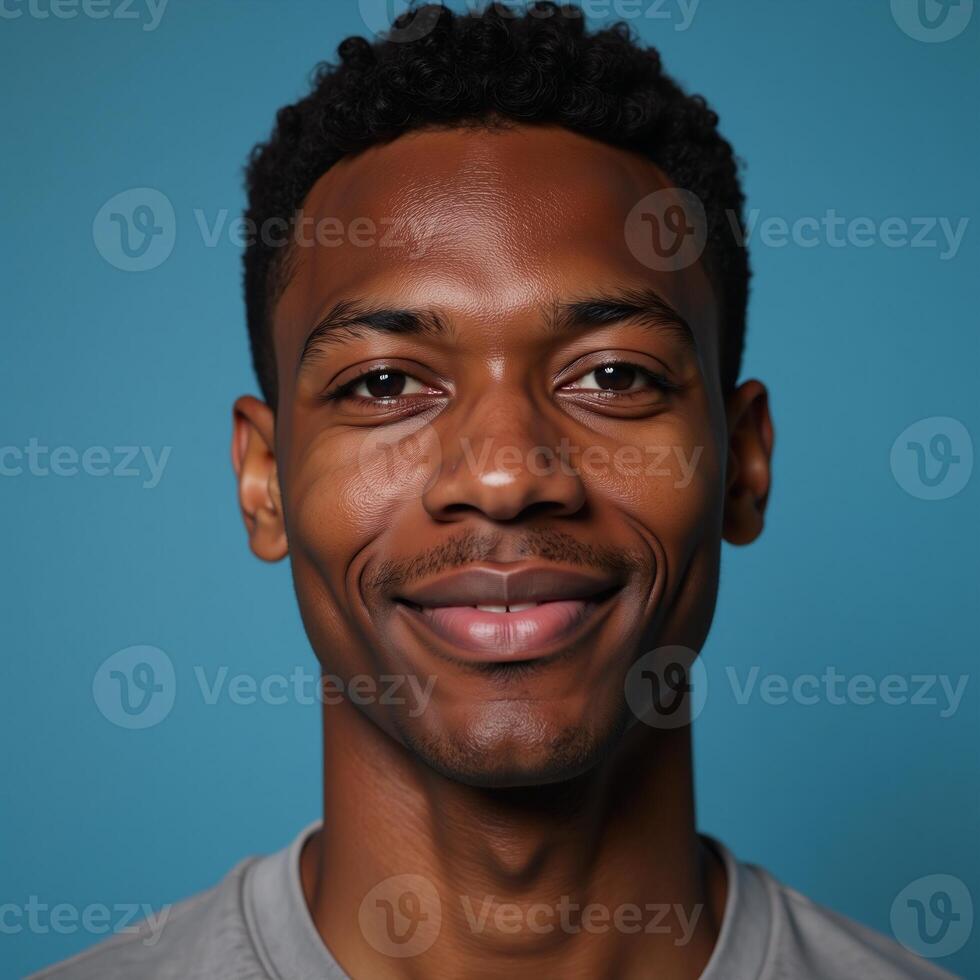 Closeup portrait of an elated African American male model with brown hair against a blurred deep sky blue background with ample copy space photo