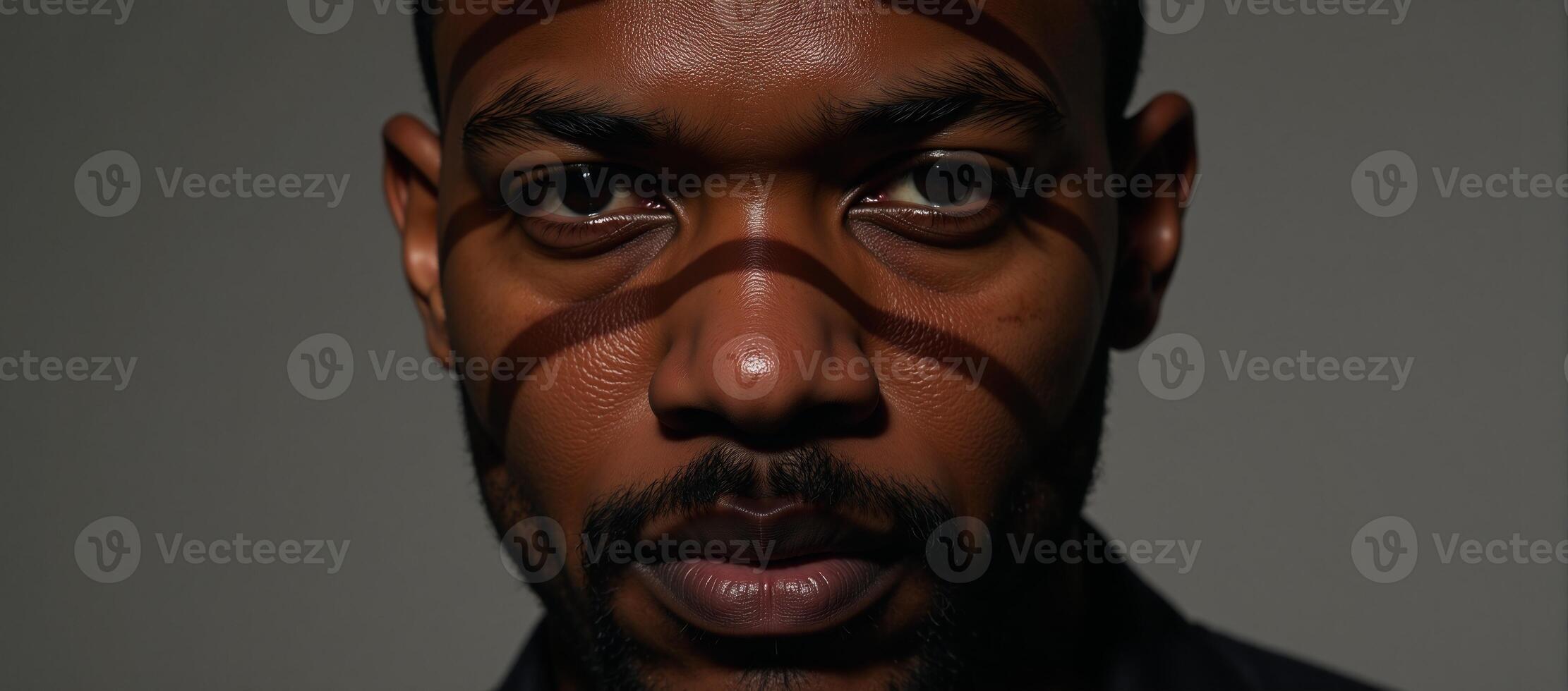 Closeup portrait of an African American man showcasing shadowy facial details and distinct striped patterns across his visage photo