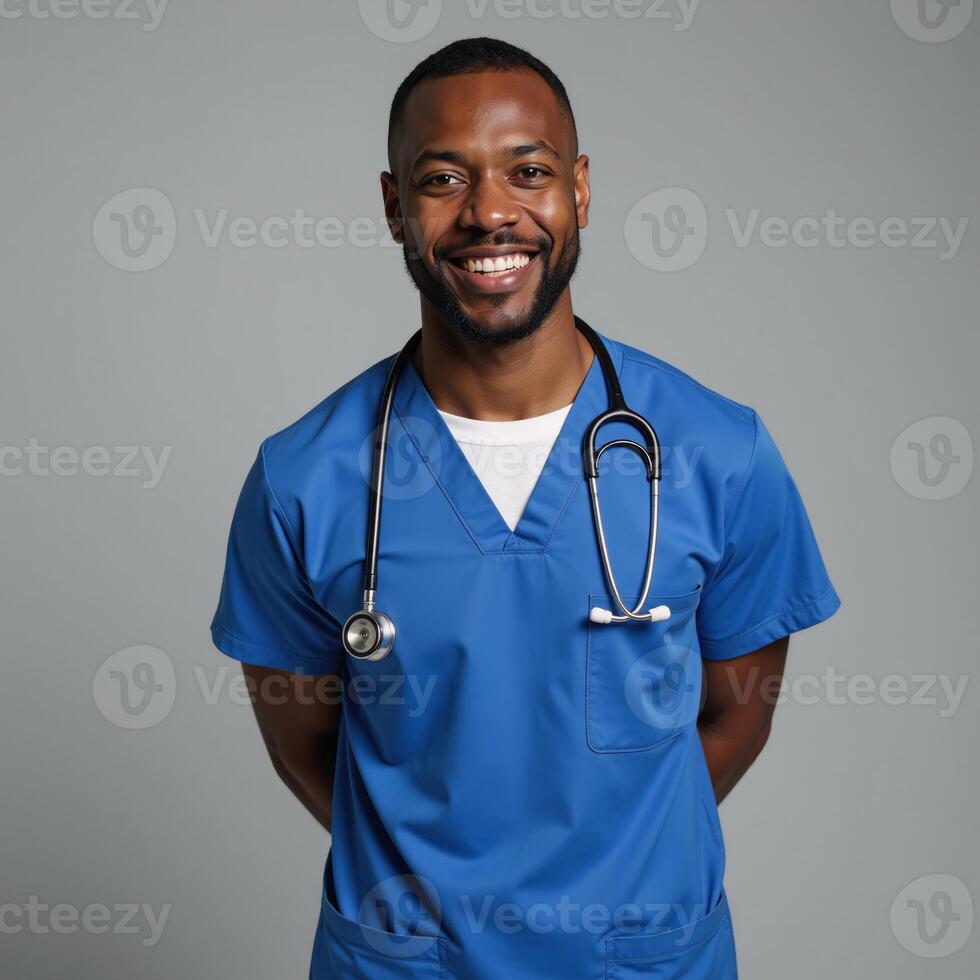 A friendly confident AfricanAmerican male nurse stands tall smiling warmly while wearing blue scrubs and a stethoscope exuding care and compassion in his expression photo