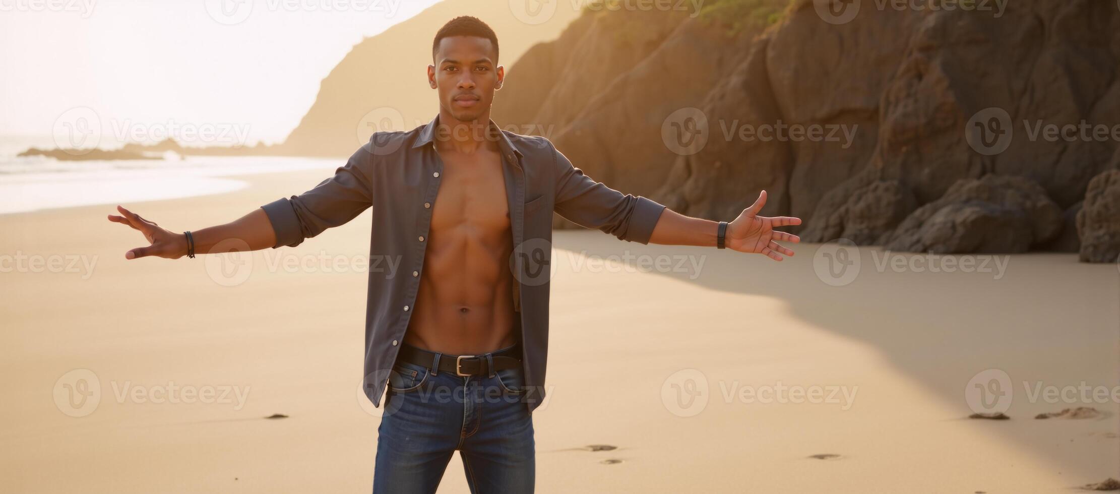 AfricanAmerican young man poses confidently with open arms on the beach photo