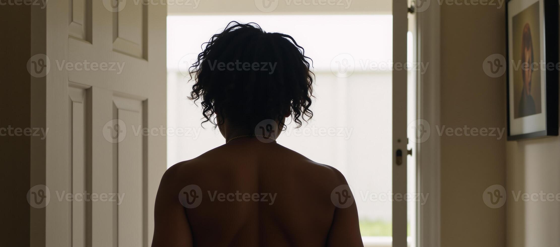 An unrecognizable AfricanAmerican woman is shown knocking on an indoor door from behind photo