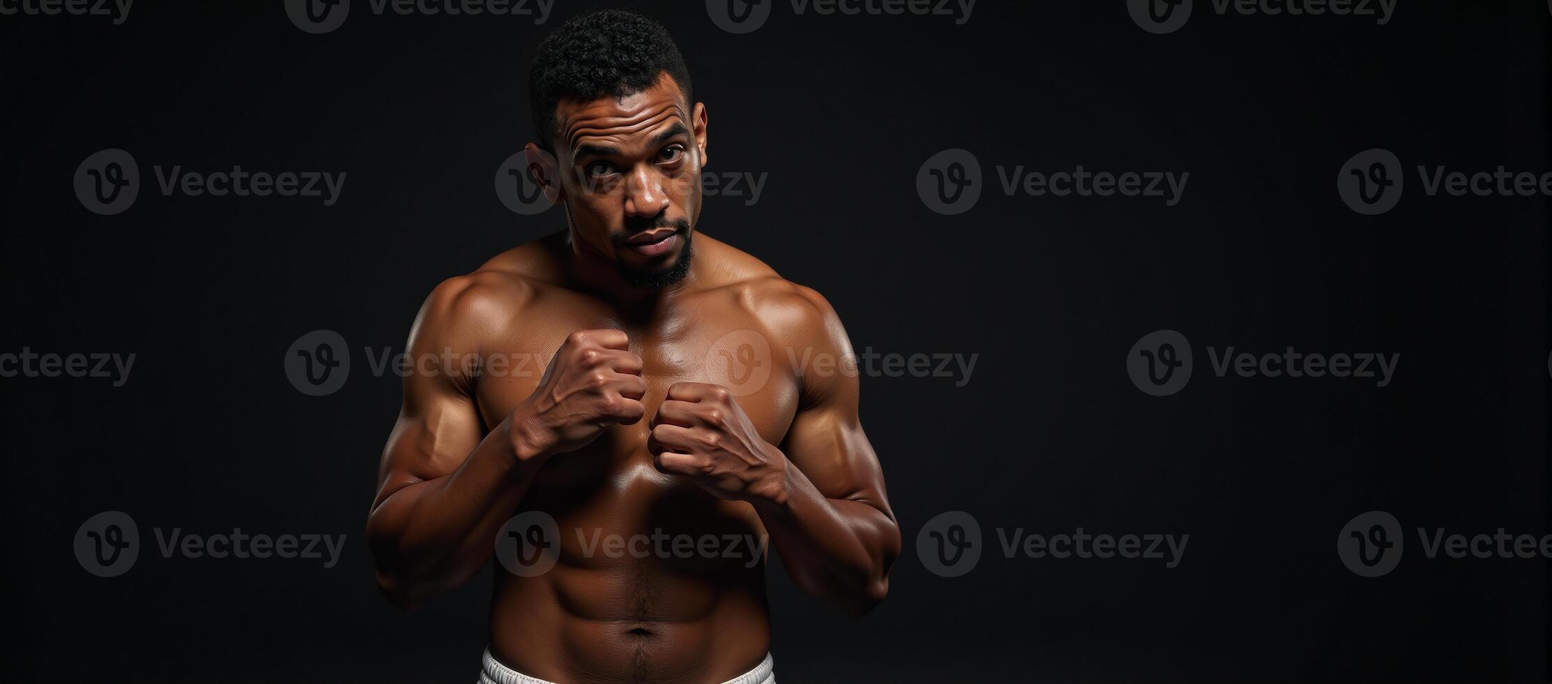 Muscular African American boxer with sweaty forehead leaning on left elbow and covering eyes with right hand photo