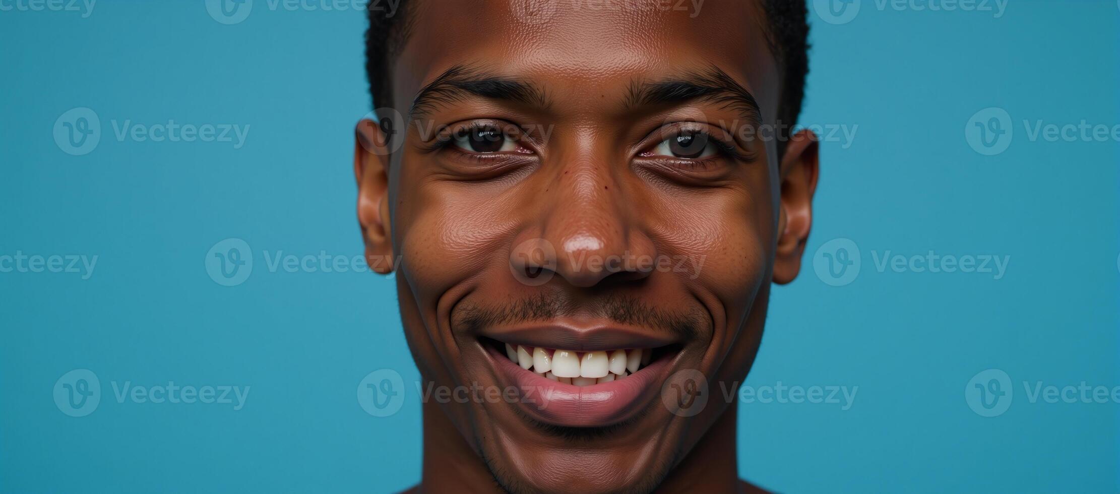 Closeup portrait of an elated African American male model with brown hair against a blurred deep sky blue background with ample copy space photo