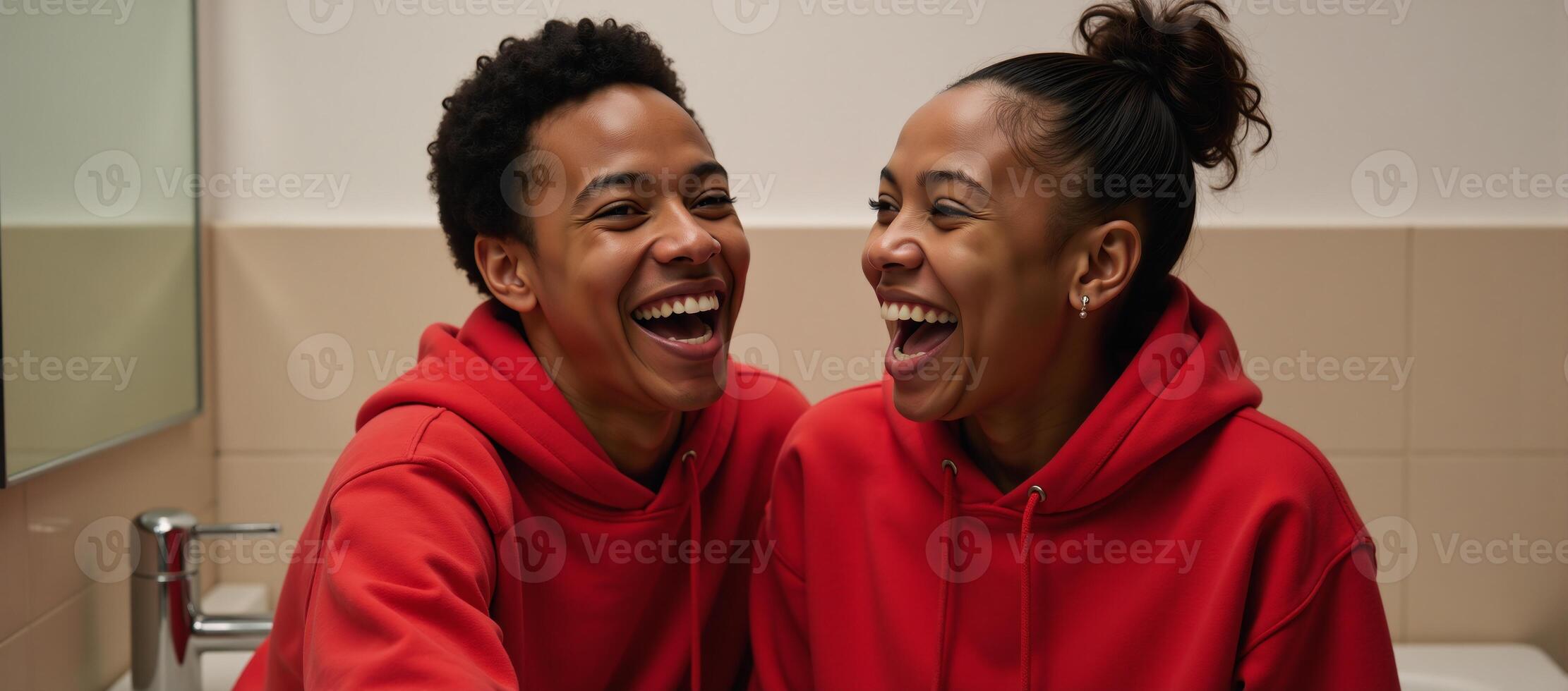 Young AfricanAmerican couple in matching red hoodies share a joyful laugh in a bathroom photo