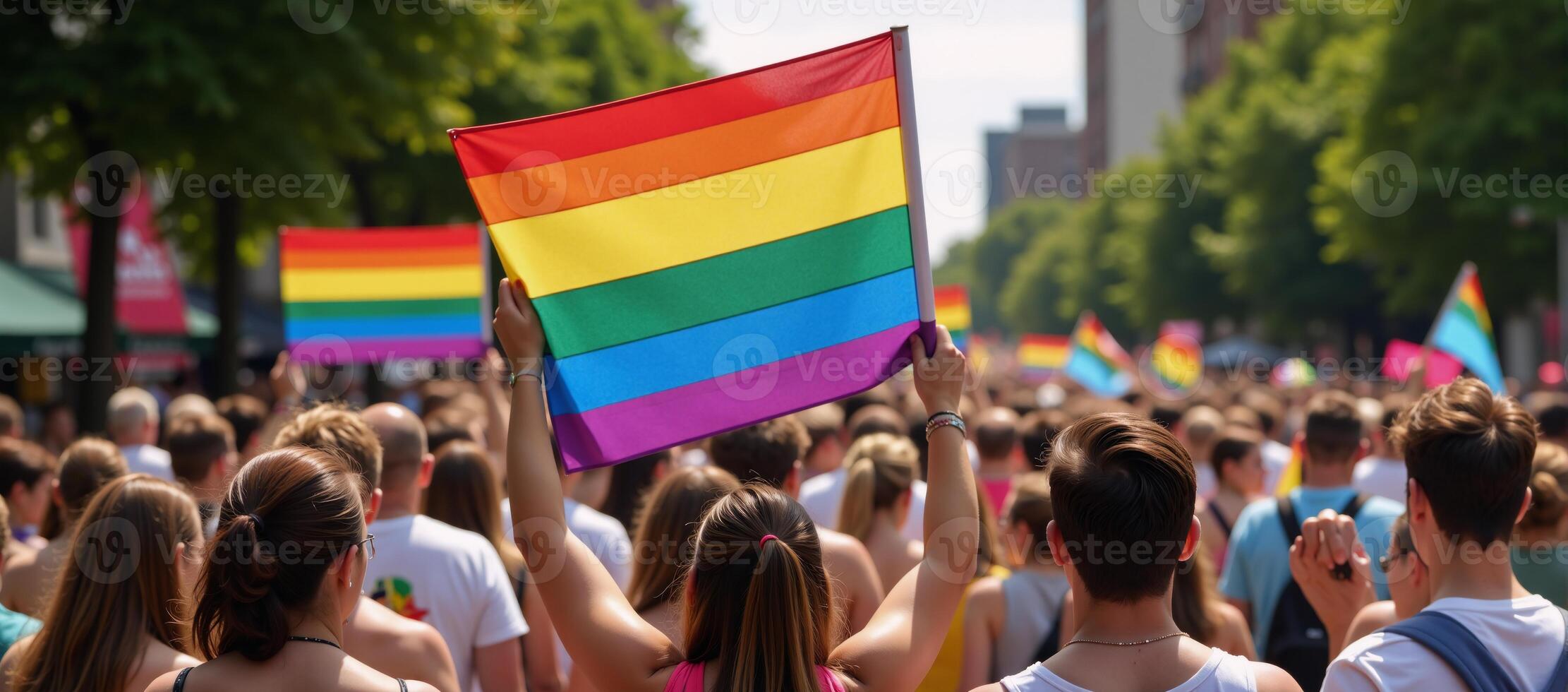 A vibrant and inclusive celebration of LGBTQ pride featuring an array of colorful individuals waving the rainbow flag at a diverse gradatedhued pride parade photo