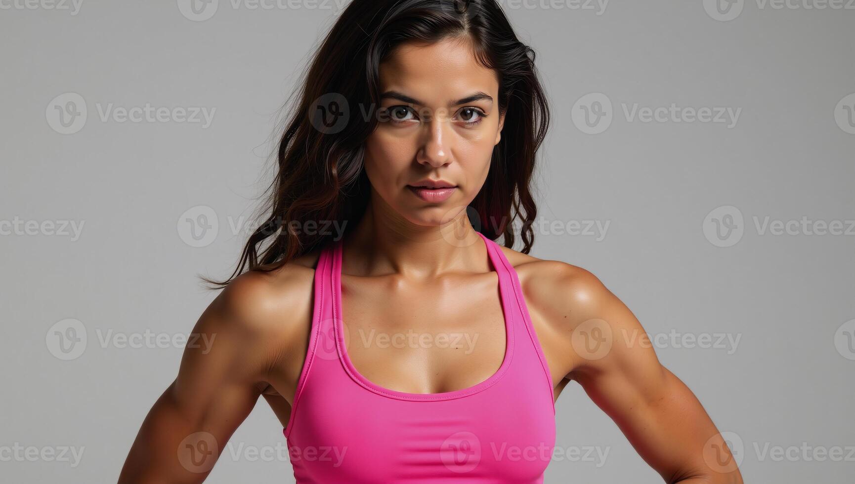 Closeup image of a fit determined athlete in pink sports bra showcasing defined muscles and curly hair photo