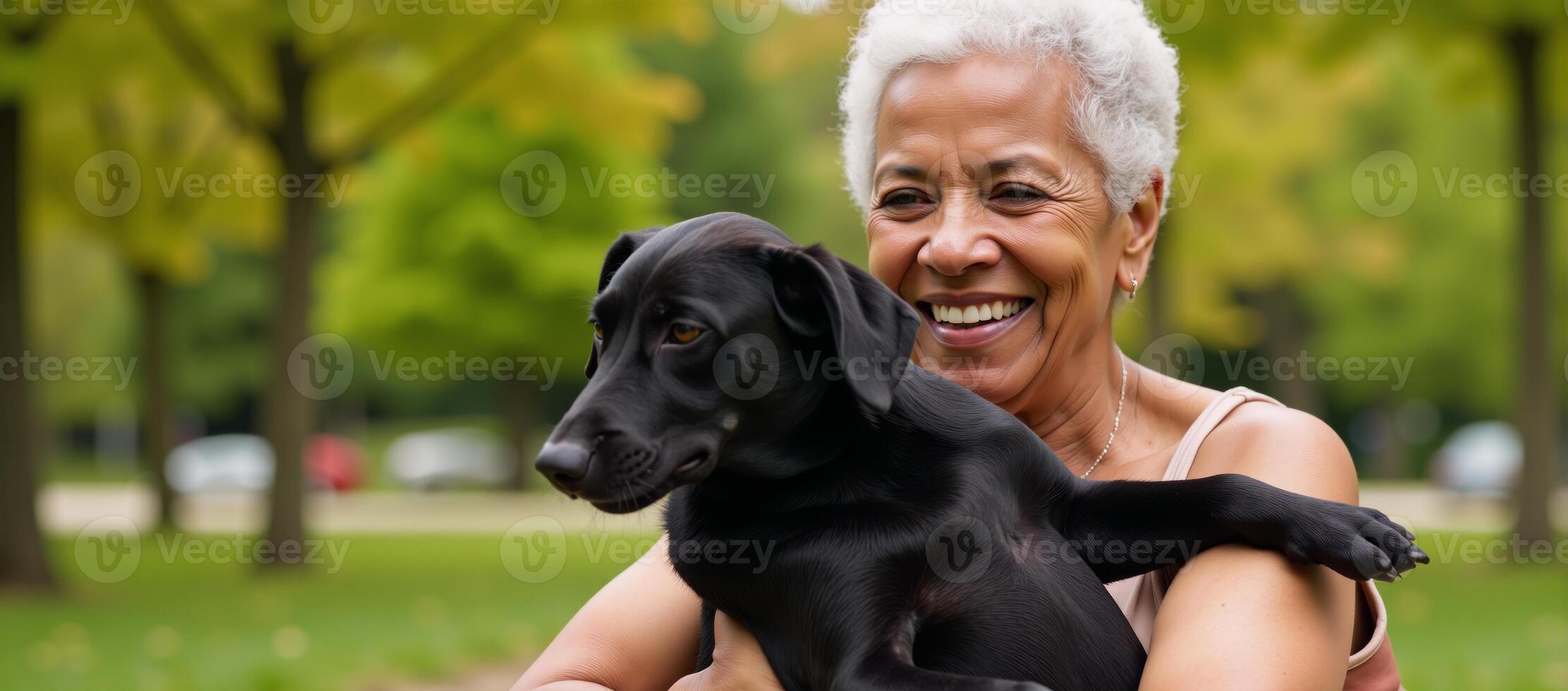 A contented African American widow embraces her pet dog during an outdoor stroll in a city park photo