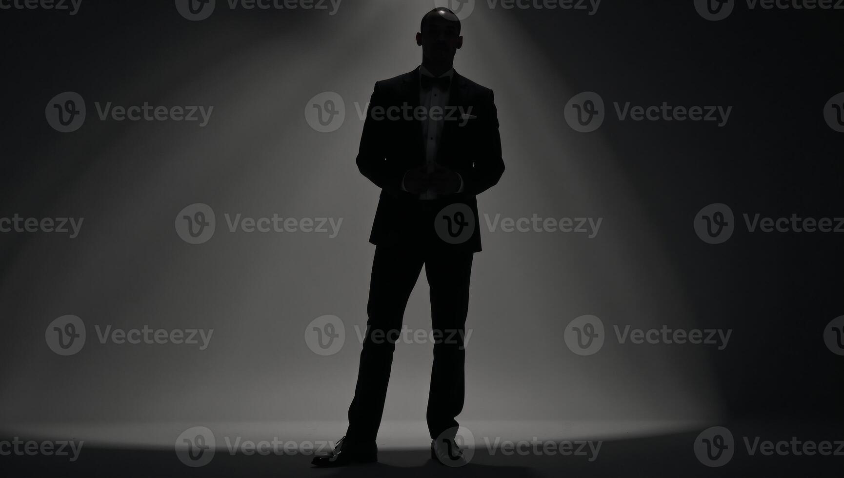 AfricanAmerican man silhouetted against a light background while wearing a tuxedo photo