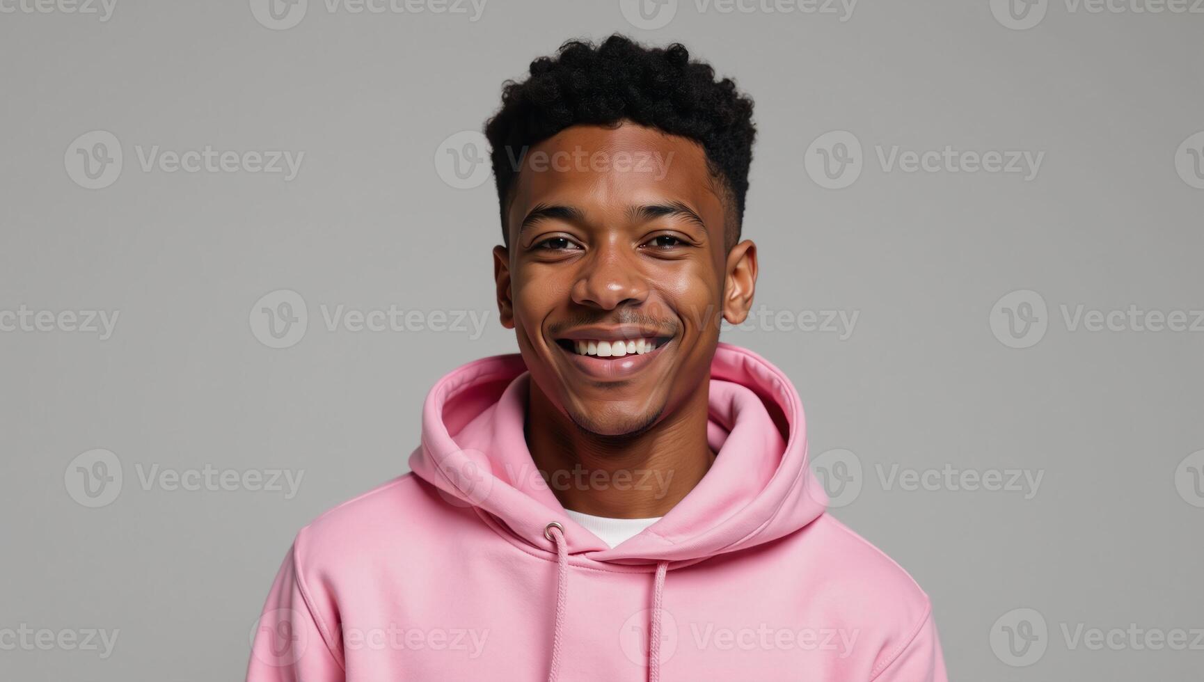 A stylish young AfricanAmerican man in a vibrant pink hoodie with a joyful demeanor photo