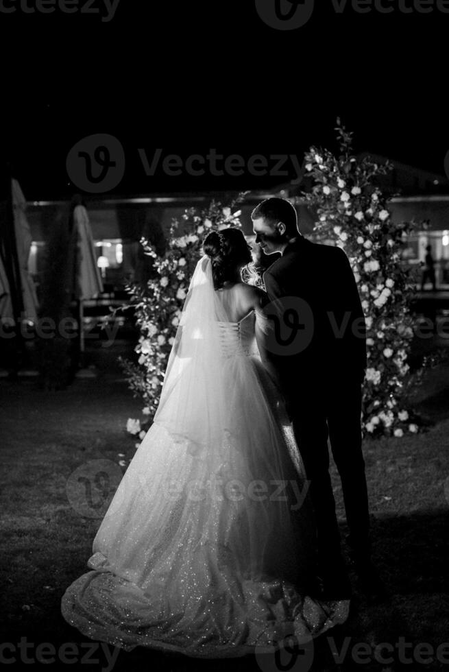 girl and guy against the background of a night wedding arch photo